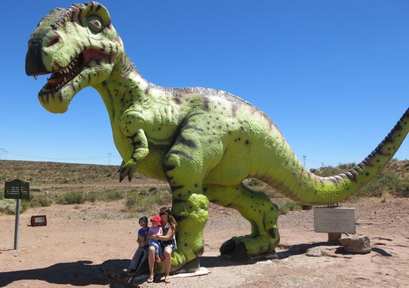 La familia a los pies del simpático dinosaurio que cuida la entrada a El Chocón.