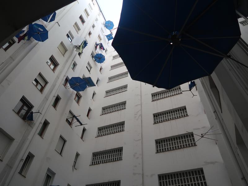 Pulmón de edificio, los paraguas son para que no se moje la ropa colgada