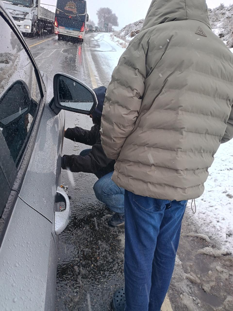 Complicado para poner las cadenas en el medio de la ruta